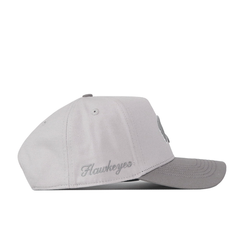 A side view of the No Rivals Iowa Hawkeyes Graphite Hat shows a light gray design with a subtly darker bill, “Hawkeyes” embroidered in script on the side, and an adjustable snap back closure.