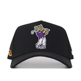 The No Rivals LSU Golf Hat - Swinging - Black is a black baseball cap featuring an embroidered cartoon tiger swinging a golf club in a purple shirt and gray pants, complete with an embroidered logo—perfect for your Gameday Fit.