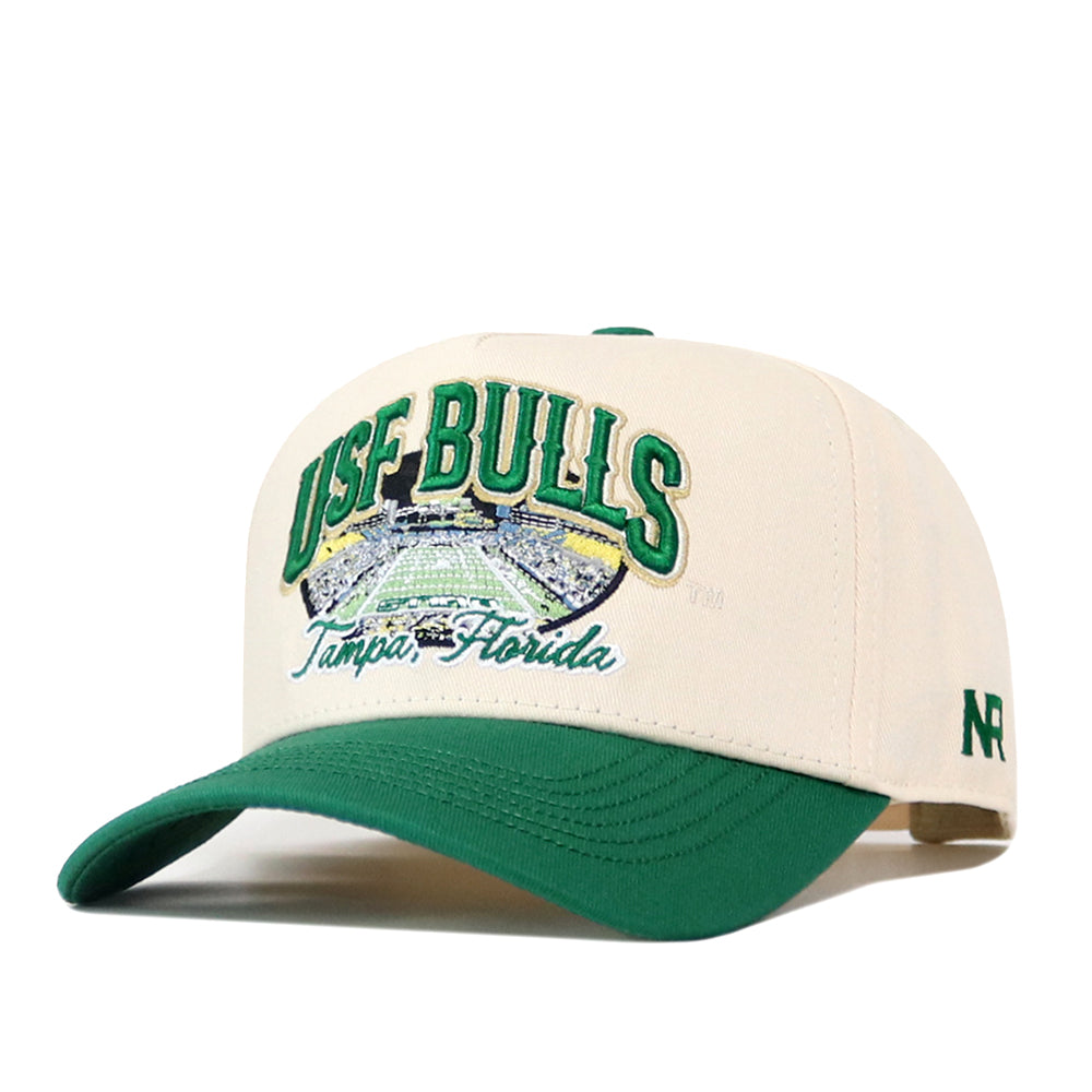 No Rivals USF Stadium Hat: a cream-colored snapback with a green brim and an embroidered patch featuring a stadium and the text USF BULLS Tampa, Florida.