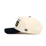 The Baylor Alma Mater Hat by No Rivals is a cream-colored, structured fit cotton cap with a black brim, embroidered text and numbers on the side, and "NR" stitched near the back left.