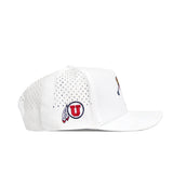 The No Rivals Utah Golf Hat - White features a structured design with ventilation holes, a flat brim, and a red U logo outlined in black with two feather designs on the side. This snapback golf hat is shown in side profile.