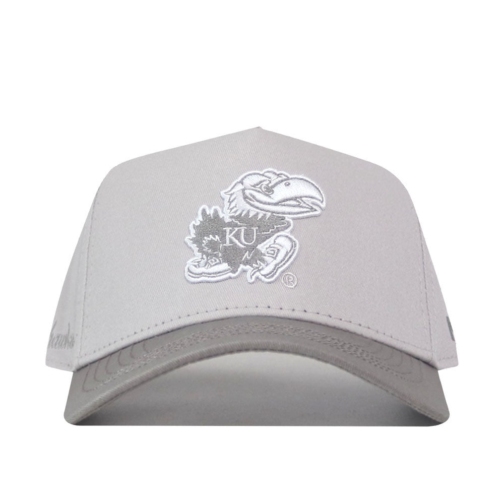 Introducing the Kansas Jayhawks Graphite Hat by No Rivals—a gray snapback cap with a white embroidered Jayhawk logo and KU on the front. This officially licensed hat is perfect for proudly supporting the University of Kansas.