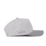 A Kansas Jayhawks Graphite Hat by No Rivals, crafted from high-quality cotton in light gray, featuring “Jayhawks” embroidered on the side and displayed from a left side profile against a white background.