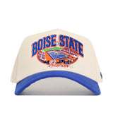 The No Rivals Boise State Broncos Stadium Hat is a beige and blue snapback featuring bold Boise State lettering, an embroidered illustration of a football stadium with logos, and “Broncos” stitched underneath—perfect for your next gameday look.