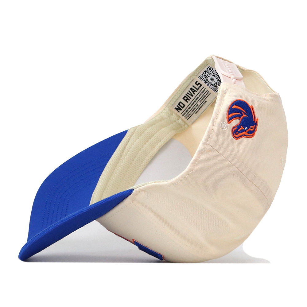 A cream and blue snap back hat, the Boise State Broncos Stadium Hat by No Rivals, is shown upside down. Inside, a tag reads NO RIVALS—just right for your gameday fit. An embroidered red and blue stylized animal head logo appears on the side of the cap.