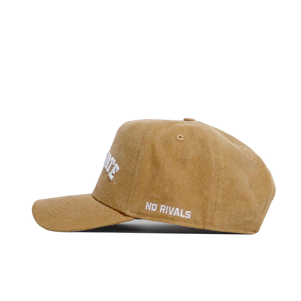 A side view of the Iowa State Rustic Hat by No Rivals shows brown cotton canvas with white “NO RIVALS” embroidery on the side. This snapback cap features a curved brim and unstructured crown for casual comfort.