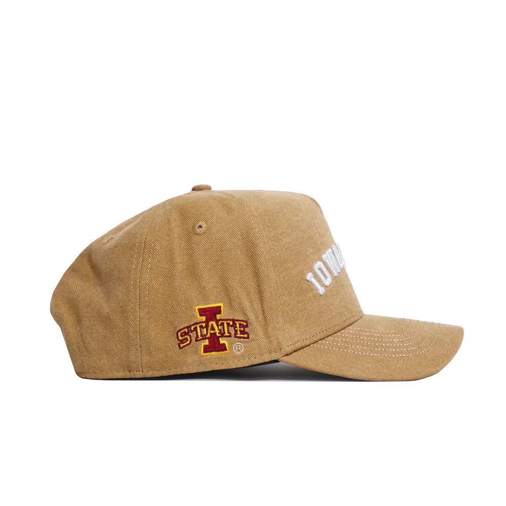 The No Rivals Iowa State Rustic Hat is a tan cotton canvas cap with a structured fit, shown from the side, displaying the Iowa State University logo and STATE in red and yellow on the side, plus partially visible white embroidery on the front.