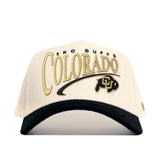 The No Rivals Colorado Buffaloes Stride Hat is a beige and black baseball cap featuring SKO BUFFS COLORADO and a buffalo logo embroidered on the front. Crafted from high-quality cotton for exceptional comfort, this structured hat includes a convenient snapback closure for an adjustable fit suitable for all sizes.