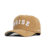 The Boise State Rustic Hat by No Rivals is a tan cotton canvas snapback with “BOISE” embroidered in large white letters on the front and “NO RISK” in small white letters on the side; features a structured fit.