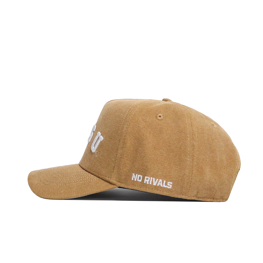 The NDSU Rustic Hat by No Rivals is a brown cotton canvas baseball cap. It features "NO RIVALS" embroidered on the side, partial "CU" letters on the front, a snapback adjustment, and is shown from the left side profile.
