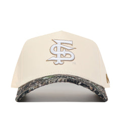 The Fresno State Camo Hat - Connector Edition by No Rivals is a cream snapback made from high-quality cotton, featuring a white and gold embroidered FS logo on the front and a camo-patterned brim.