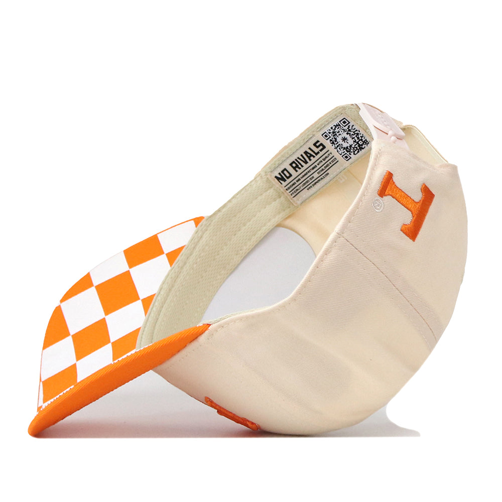 Introducing the Tennessee Volunteers Neyland Checkard Hat by No Rivals—a cream snapback cap showcasing an embroidered orange “T” on the front and an orange-and-white checkerboard pattern on the underside of the brim. The interior tag proudly reads NO RIVALS, making this hat a perfect addition to your gameday fit.