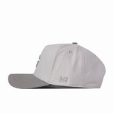 A Georgia Graphite Hat by No Rivals, featuring a light gray snapback design with a darker gray brim, is shown from the side against a plain white background. The embroidered NR near the back offers a subtle logo detail, making it perfect for your gameday fit.