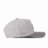 A side view of the Georgia Graphite Hat by No Rivals, this light gray snapback cap features a flat, darker gray brim and an embroidered “Georgia Dawgs” cursive logo above the ear. It’s the perfect accessory to complete your gameday look.