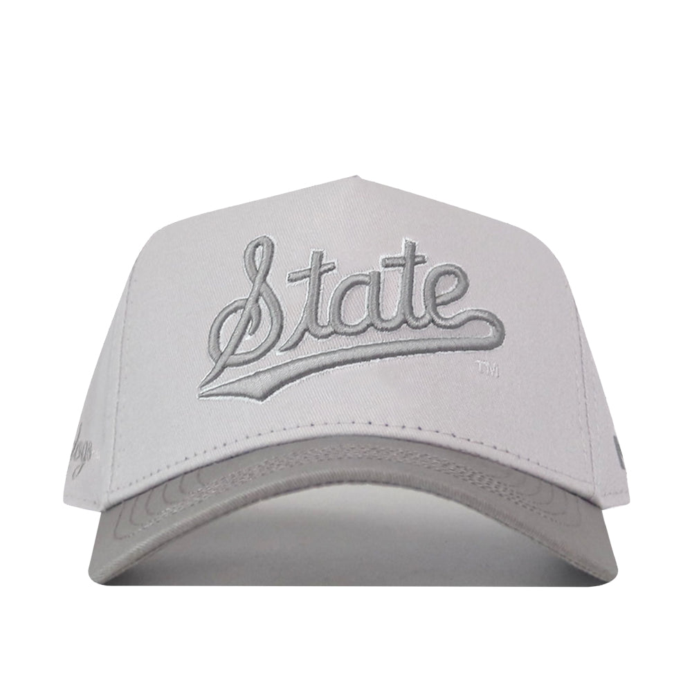 A Mississippi State Graphite Hat by No Rivals, featuring a light gray snapback design and “State” embroidered in large, cursive silver letters on the front. The background is white.
