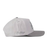 Introducing the No Rivals Mississippi State Graphite Hat: this light gray baseball cap features a flat brim and an adjustable snap back closure for your ideal gameday fit. “Bulldogs” is embroidered in gray script on the side, while a raised embroidered logo appears partially visible on the front panel.