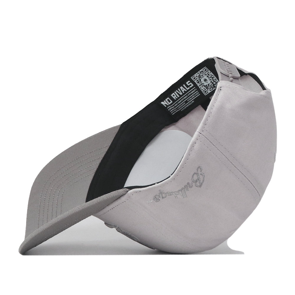 The Mississippi State Graphite Hat by No Rivals is displayed upside down, revealing the inside label and a QR code alongside bold NO RIVALS text. Both the brim and crown are visible, featuring an embroidered logo and text on the outer side—making it a great addition to your gameday outfit.