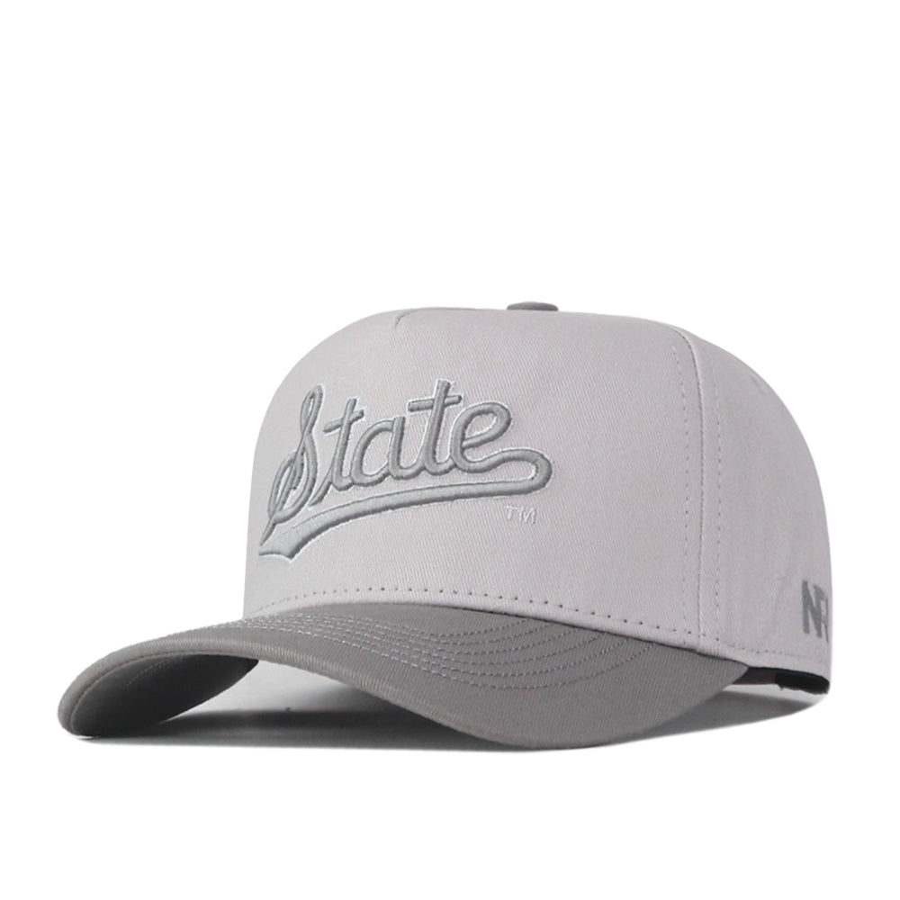 The No Rivals Mississippi State Graphite Hat features an embroidered “State” logo in matching gray thread on the front. With its structured crown, curved brim, and adjustable snap back closure, this light gray cap is perfect for elevating your gameday look.