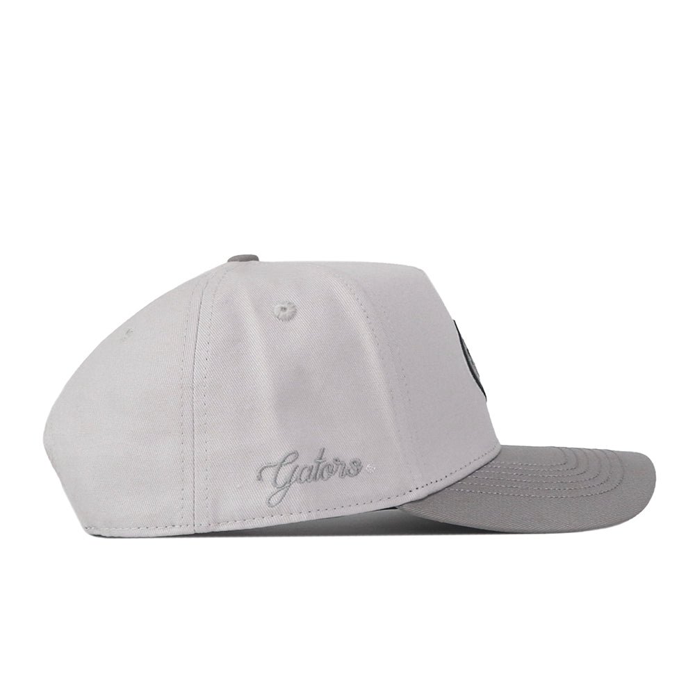 The No Rivals Florida Gators Graphite Hat features a light gray design with a contrasting darker gray brim, displayed in a side view. “Gators” is subtly embroidered near the back in coordinating gray thread, providing an understated embroidered logo detail to complete your gameday ensemble.