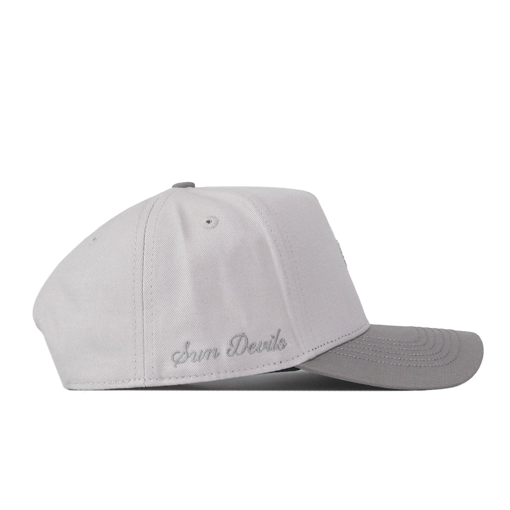 A light gray Arizona State Graphite Hat by No Rivals, featuring a darker gray brim and a side profile view. This officially licensed cap displays “Sun Devils” embroidered in gray thread above the back of the brim and offers an adjustable fit with its snap back closure.