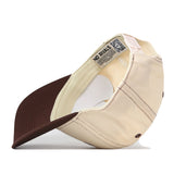 The No Rivals Bowling Green State Falcons Vintage Hat, crafted from high-quality cotton in beige and brown, is shown positioned on its side to reveal the inside labels, stitching details, and a QR code on the inner tag. This snapback cap features an embroidered logo for a premium touch.