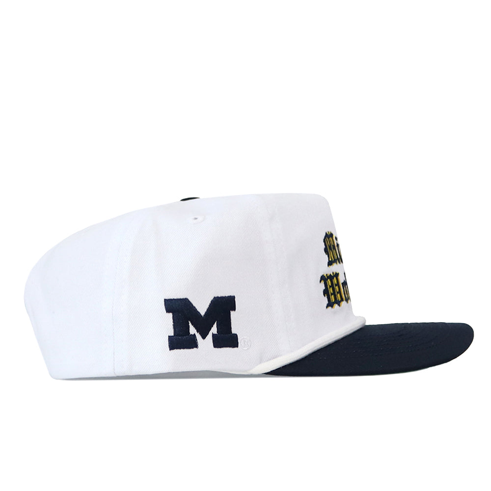 Michigan Old English Rope Hat, a white five-panel hat with a navy blue flat brim, navy blue rope detail, side M logo, yellow and navy Old English text on the front, and a snapback adjustment.
