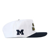 Michigan Old English Rope Hat, a white five-panel hat with a navy blue flat brim, navy blue rope detail, side M logo, yellow and navy Old English text on the front, and a snapback adjustment.