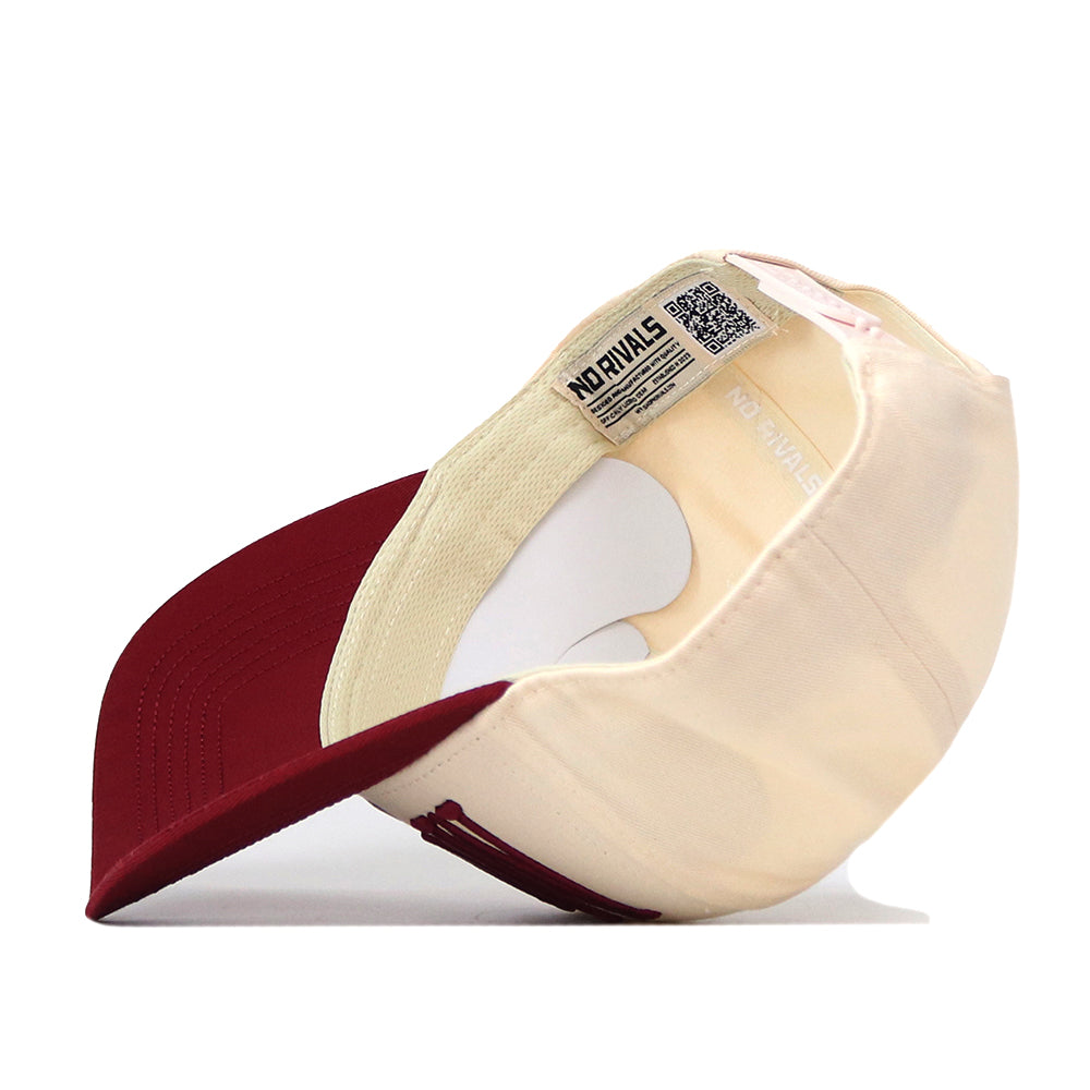The Montana Grizzlies Stride Hat by No Rivals is pictured upside down, displaying the inside label with the brand’s signature “NO RIVALS” and a visible QR code beneath the cream and maroon brim—perfectly embroidered logos make this snapback an ideal fit for gameday.