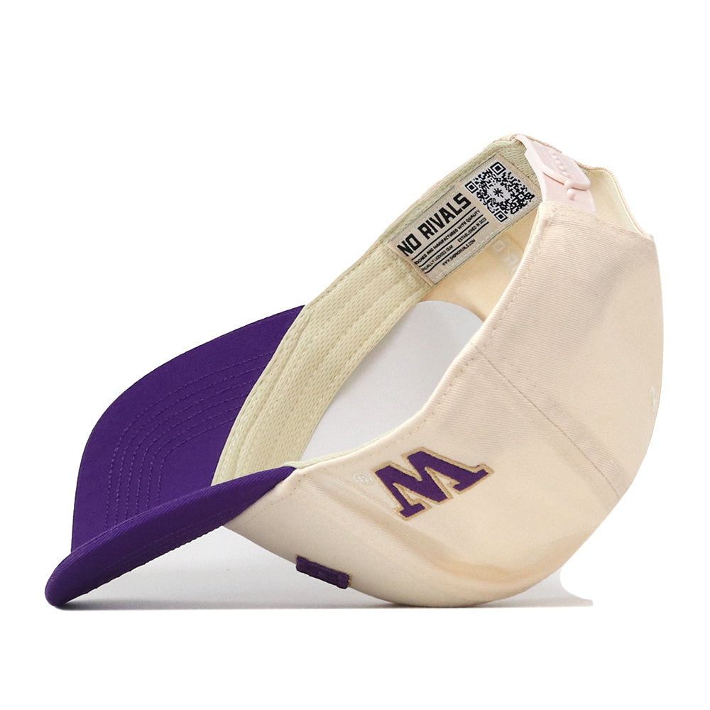 The Right Side Up Huskies Hat - UW - Classic by No Rivals is a cream and purple baseball cap featuring a purple, embroidered letter M on the side. The inside tag reads “NO RIVALS” and includes a QR code. This officially licensed cap is shown positioned on its side with the brim facing left, and offers a convenient snap back adjustment for a customizable fit.