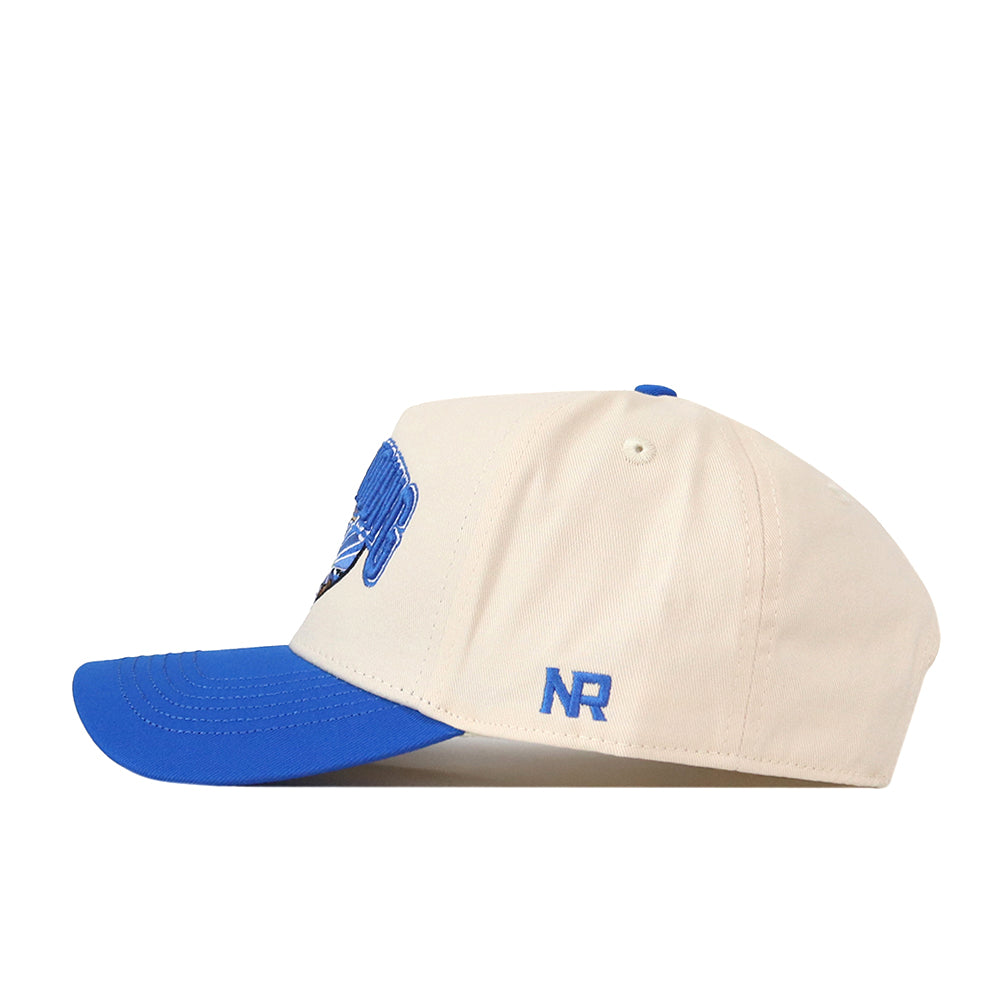 The No Rivals BYU Cougars Stadium Hat features a beige crown with a blue brim and blue embroidered NR initials on the side, shown in a left-facing profile view—this snapback is the perfect way to complete your gameday look.
