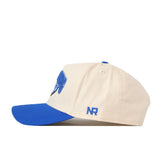 The No Rivals BYU Cougars Stadium Hat features a beige crown with a blue brim and blue embroidered NR initials on the side, shown in a left-facing profile view—this snapback is the perfect way to complete your gameday look.