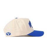 Show your Cougar pride with the BYU Cougars Stadium Hat by No Rivals—a cream and blue snapback featuring a blue Y logo embroidered on the side and a matching blue bill, displayed in side profile against a white background. The perfect finishing touch for your gameday look.