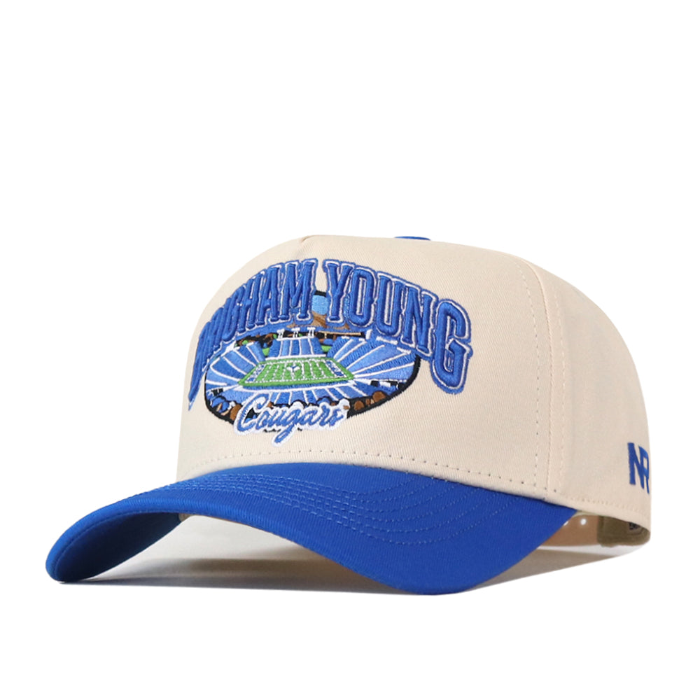 The No Rivals BYU Cougars Stadium Hat is a beige and blue snapback featuring detailed embroidered Brigham Young Cougars logos and a football stadium on the front—perfect for elevating your gameday look.