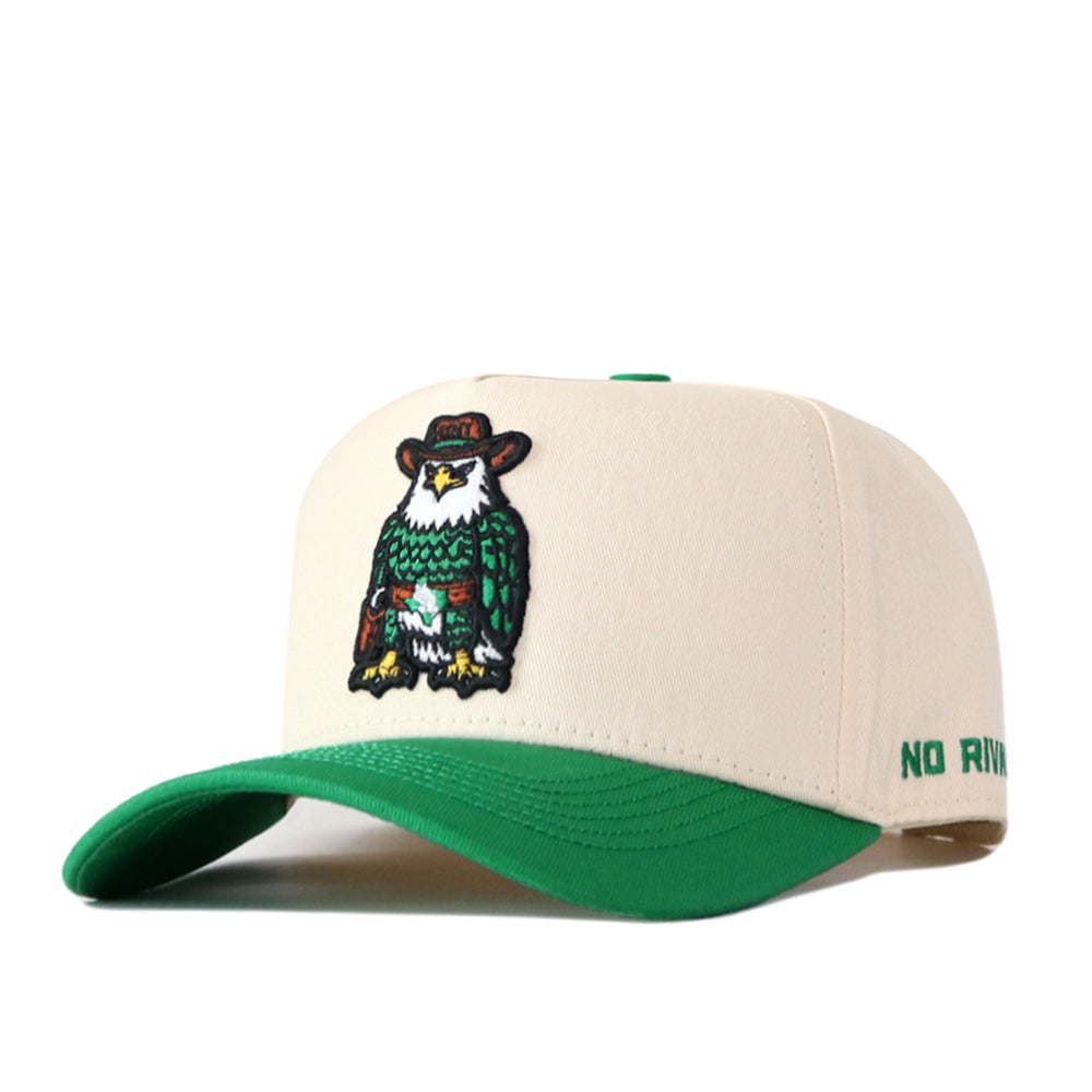 The UNT Desert Scrappy Logo Hat by No Rivals is a beige and green snapback crafted from a soft cotton blend, featuring an embroidered owl in a cowboy hat on the front, detailed with patch embroidery and partially visible “NO RIV” lettering on the side of the brim.