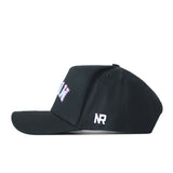 A black FIU Panthers | Upside Down Miami Hat - Blackout by No Rivals is shown from the side, featuring embroidered white NR initials on the side and partially visible pink and white text on the front.