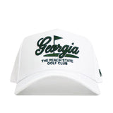 The No Rivals Georgia Clubhouse Hat is a white snapback featuring "Georgia" in black script, a small flag graphic, and "The Peach State Golf Club" embroidered below. Structured fit with a soft poly-cotton blend for lasting comfort.