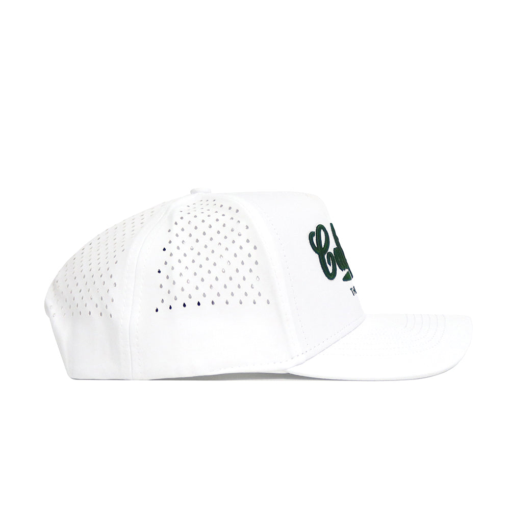The No Rivals California Clubhouse Hat is a white snapback with side ventilation holes and partially visible green embroidery on the front. Made from a polyester-cotton blend, it’s shown in left profile against a white background.