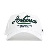 The Arkansas Clubhouse Hat by No Rivals features a structured fit, white design, large green "Arkansas" embroidery with a golf flag above, and "The Natural State Golf Club" in smaller text below. Made from a soft polyester-cotton blend.