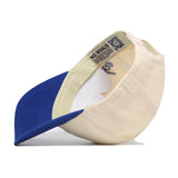 The Kansas Jayhawks Halftime Hat by No Rivals is shown turned inside out, revealing its beige exterior with a blue brim, inner labels, detailed stitching, and a QR code on the sweatband. This officially licensed snapback cap also features embroidered logos for an authentic look.