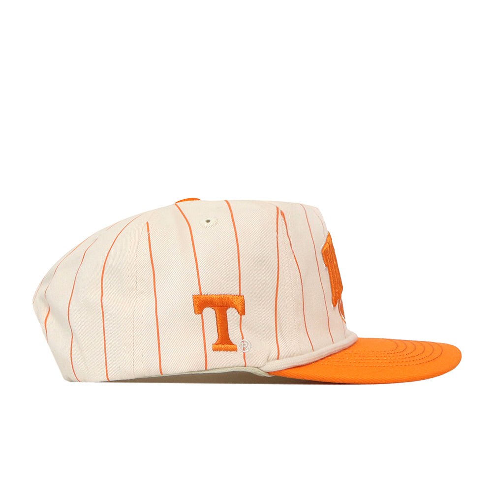 Introducing the No Rivals Tennessee Pinstripe Traditions Hat—a stylish white baseball cap featuring thin orange vertical stripes, an orange bill, and an embroidered orange “T” logo on the side. Crafted from a comfortable cotton blend for lasting wear, this hat also includes a snap back closure to ensure a perfect fit.