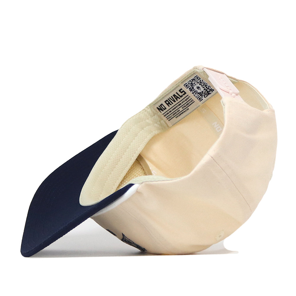 The Penn State Vintage Block Hat by No Rivals is displayed upside down, revealing the inside label with NO RIVALS text and a QR code beneath the brim. This officially licensed beige and navy snapback cap features an embroidered Penn State logo for a stylish and authentic touch.