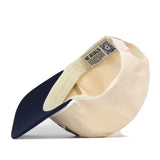 The Penn State Vintage Block Hat by No Rivals is displayed upside down, revealing the inside label with NO RIVALS text and a QR code beneath the brim. This officially licensed beige and navy snapback cap features an embroidered Penn State logo for a stylish and authentic touch.