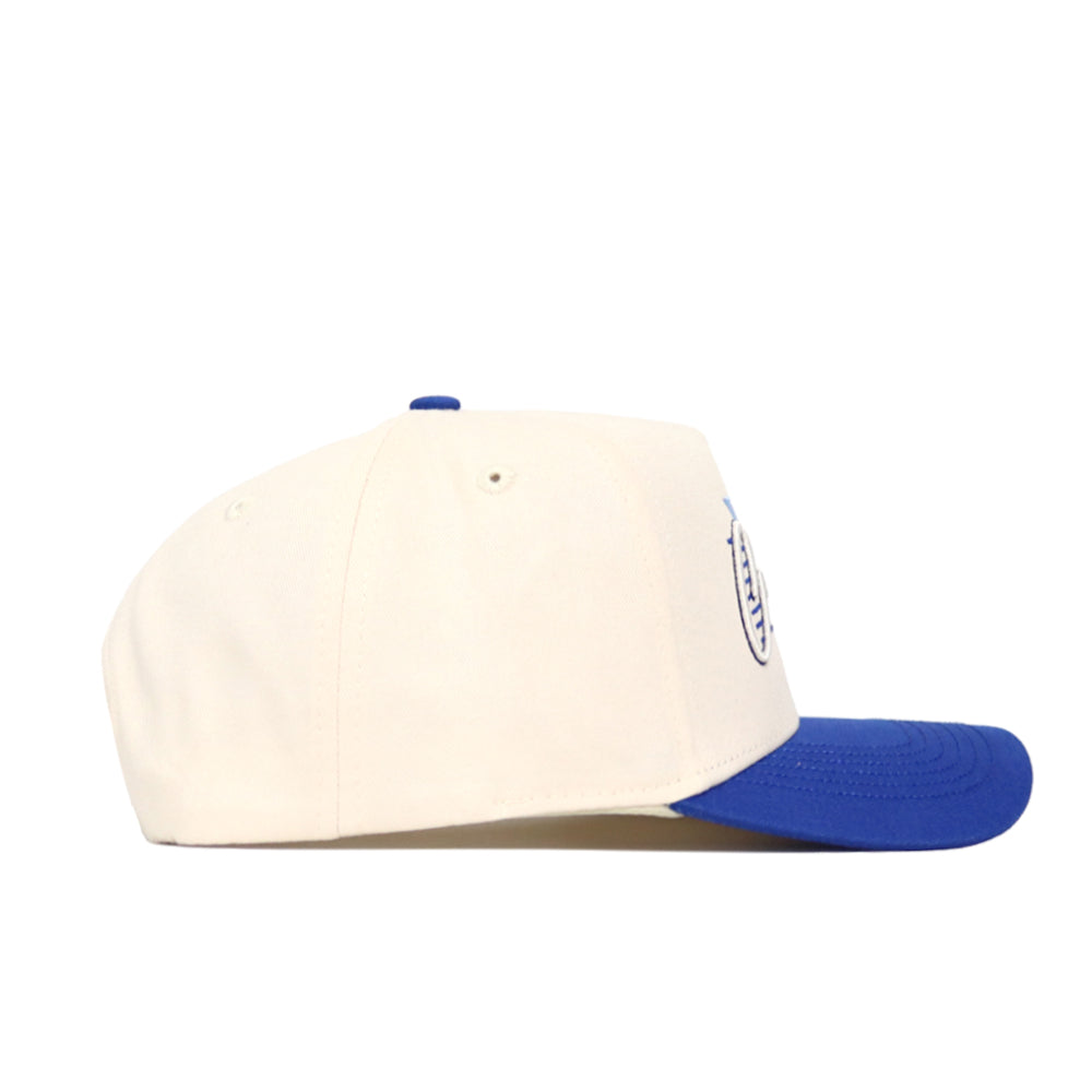 The No Rivals Creighton Triangle Game Cap Hat is shown in a side view, featuring a structured fit with a white crown and blue brim, set against a plain white background.