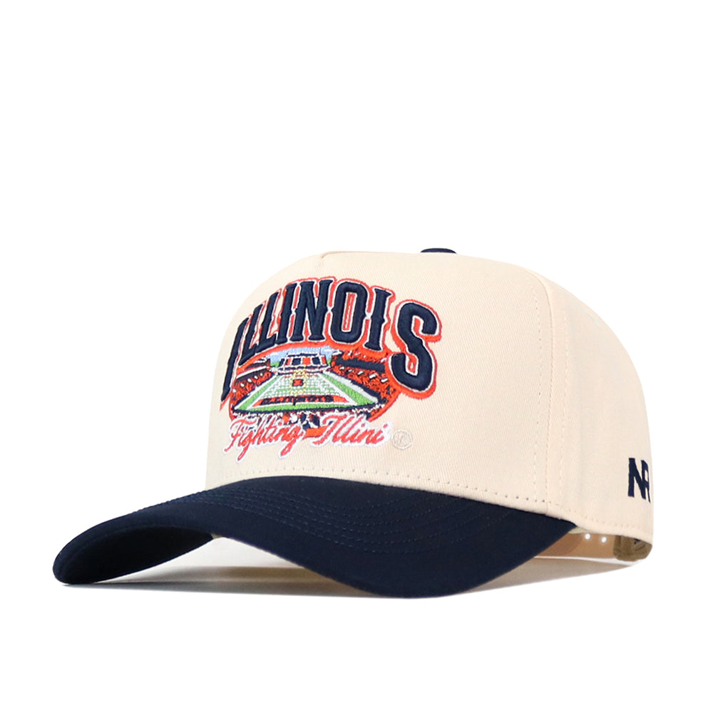 Show your team pride with the Illinois Fighting Illini Stadium Hat by No Rivals. This cream and navy snapback features the Illinois Fighting Illini and an embroidered stadium design on the front, a navy bill, and detailed logos—including the New Era logo stitched on the side. This officially licensed cap is perfect for any fan.