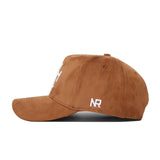 The No Rivals Wake Forest Heritage Hat is a brown suede baseball cap with a curved brim and white NR embroidery on the side, shown in a side view against a plain white background.