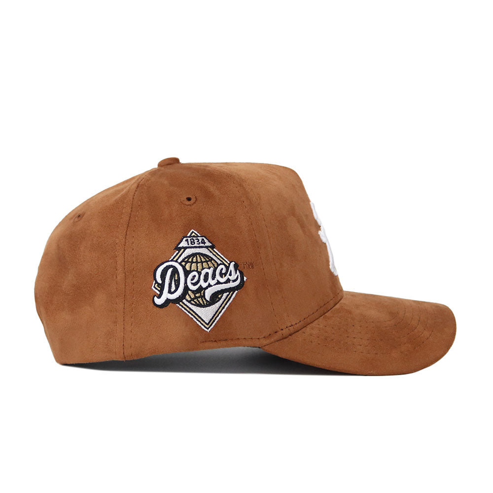 The Wake Forest Heritage Hat by No Rivals is a brown suede baseball cap with a diamond "Deacs" 1834 patch embroidered on the side. This officially licensed snapback blends timeless style and campus pride.