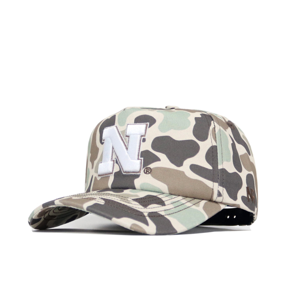 The Nebraska Huntsman Hat by No Rivals features a 5-panel Duck Camo design with a prominent white embroidered N on the front, shown against a white background.