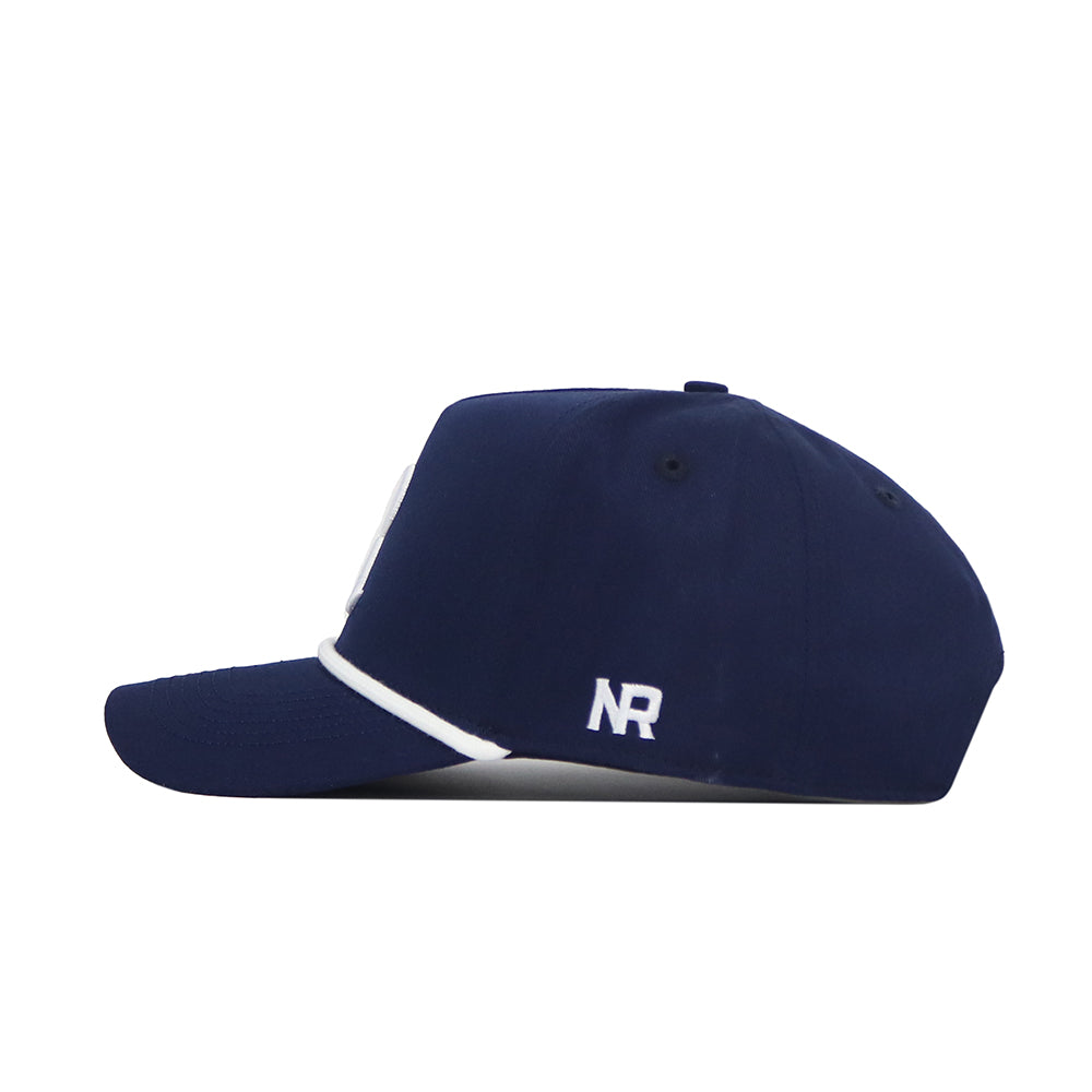 The Rice Guys Hat - Navy by No Rivals features a side view with a curved brim, white trim, and an embroidered white "NR" logo near the back. This officially licensed snapback adds style to any casual outfit.