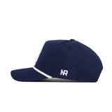 The Rice Guys Hat - Navy by No Rivals features a side view with a curved brim, white trim, and an embroidered white "NR" logo near the back. This officially licensed snapback adds style to any casual outfit.