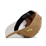 The South Dakota State Rustic Hat by No Rivals is a tan cotton canvas hat with a yellow cartoon bird embroidered on the side, a beige adjustable strap, and "NO RIVALS" on the inside label. Enjoy its structured fit for long-lasting comfort.